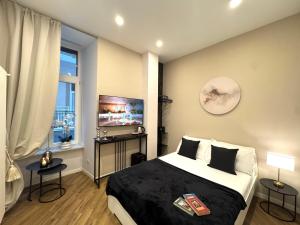 a bedroom with a bed and a flat screen tv at MILUAR Relais - Piazza Fuga in Naples