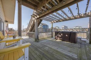 a wooden deck with a view of the beach at 7039 - A Wave From It All in Rodanthe