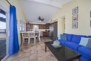 a living room with a blue couch and a table at 7039 - A Wave From It All in Rodanthe +26 photos