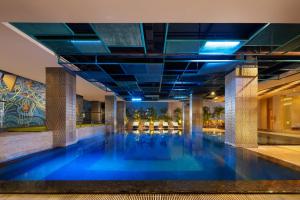 a swimming pool in a building with blue water at MORAZEN Surabaya in Surabaya