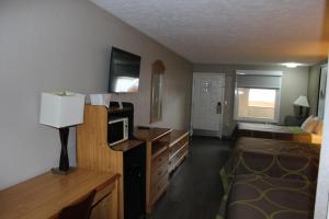 a room with a bedroom with a bed and a desk at Super 8 by Wyndham Fort Chiswell Wytheville Area in Max Meadows