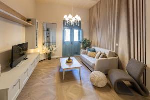 a living room with a couch and a tv at Pawlina Boutique Residence in St. Paul's Bay