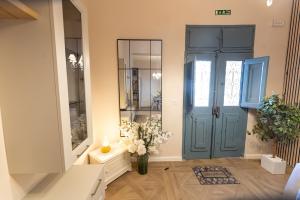 a hallway with a blue door and a vase of flowers at Pawlina Boutique Residence in St. Paul's Bay +48 photos