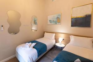 two beds in a small room with two lamps at Pawlina Boutique Residence in St. Paul's Bay