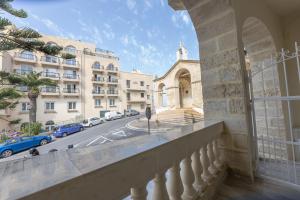 a balcony with a view of a building and a street at Pawlina Boutique Residence in St. Paul's Bay