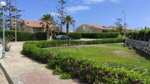 a park with a lawn in front of a house at Modern Luxury Villa Steps from the Sea North Coast in Borg El Arab