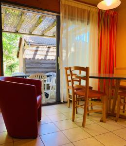 a dining room with a table and chairs and a balcony at VVF Sud Vercors in Die