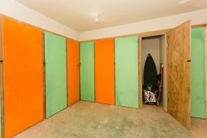 Habitación vacía con paredes de color naranja y verde. en Hotel Pousada Blauset en Taíba