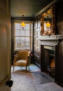 a living room with a chair and a fireplace at The Old House Apartment in Shrewsbury