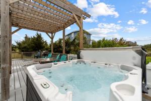 a hot tub on a deck with a pergola at 7219 - C-Waves in Salvo
