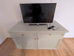 a white dresser with a tv on top of it at Apartment L i e b l i n g s o r t in Golling an der Salzach +22 photos
