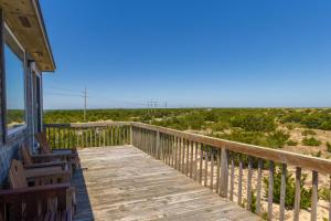 a wooden porch with chairs and a view of the beach at 7504 - Sunrise-Sunset in Avon