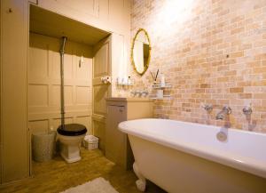 a bathroom with a white tub and a toilet at The Old House Apartment in Shrewsbury +24 photos