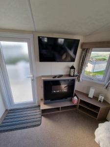 a living room with a flat screen tv and a flat screen at Swanage Caravan in Swanage