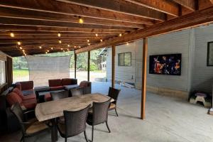 a patio with a table and chairs and a tv at Driftwood in Ronald