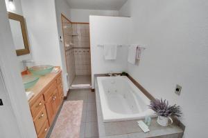 a white bathroom with a tub and a sink at Driftwood in Ronald +43 photos