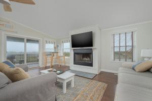 a living room with a couch and a fireplace at 7916 - Hatteras Vista in Hatteras