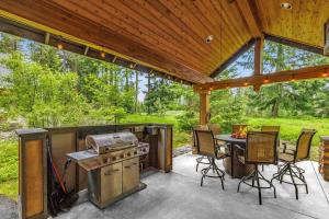 a patio with a grill and a table and chairs at Gathering Place in Cle Elum
