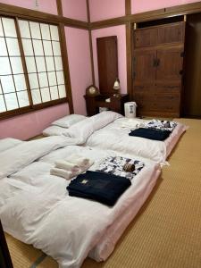 two beds in a room with towels on them at 艶子の家 in Narashino