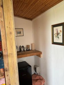 a room with a wooden shelf and a small refrigerator at Swedish Rustic Cabin perfect for bird watching in Emsworth