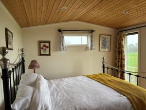 a bedroom with a bed with a wooden ceiling at Swedish Rustic Cabin perfect for bird watching in Emsworth