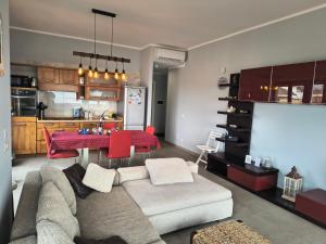 a living room with a couch and a table and a kitchen at My Sunset in Torvaianica