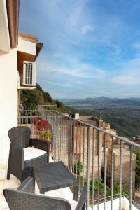 a balcony with chairs and tables on a building at B&B Golgo in Baunei