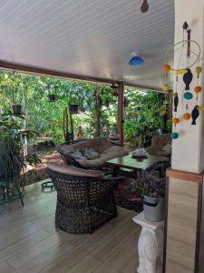 a screened in porch with a table and chairs at Melizas Garden Pousada em Foz do Iguaçu in Foz do Iguaçu