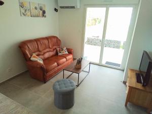 a living room with a brown leather couch and a table at La CHANTERELLE in Mortagne
