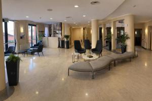 a lobby with couches and chairs in a building at Hotel San Rocco in Muggia +45 photos