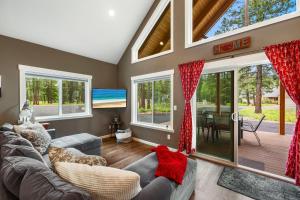 a living room with a couch and windows and a table at Crimson Cabin in Ronald