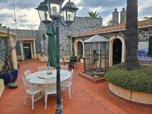 a patio with a table and chairs and a street light at Casa da Minha Avó in São Pedro de Solis