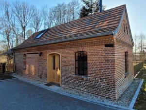 a brick building with a brown door on a street at Alte Schmiede in Schwielochsee +15 photos