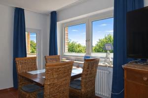 a dining room with a table and chairs and a window at fewo1846 - Ostseebad - Apartment mit 2 Schlafzimmern und Meerblick in Flensburg