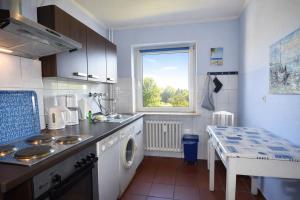 a kitchen with a sink and a washing machine at fewo1846 - Ostseebad - Apartment mit 2 Schlafzimmern und Meerblick in Flensburg