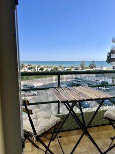 a table and chairs on a balcony with a view of a harbor at Pérola VerdeMar in Quarteira +11 photos