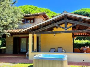 a house with a hot tub in the yard at Ville Di Villa Biserno in San Vincenzo