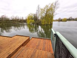 a wooden dock in the middle of a lake at The Hideaway Pod in Chelmsford +5 photos