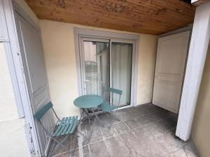 a balcony with a table and two chairs on a porch at Le Spa des Laurières in Bagnères-de-Bigorre