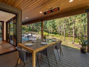 a dining room with a table and chairs on a deck at Whispering Woodland in Cle Elum