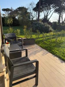 a patio with two chairs and a table and a table and chairs at Artemide Resort, Suite Spa Elysia in Lido Di Fondi