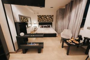 a bedroom with a bed and a table and a chair at Artemide Resort, Suite Spa Elysia in Lido Di Fondi
