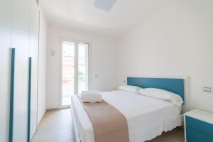 a white bedroom with a large bed and a window at Camilla al mare in Tortoreto Lido