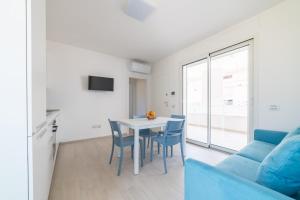 a living room with a table and chairs and a blue couch at Camilla al mare in Tortoreto Lido