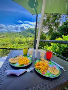 a table with two plates of food and glasses of milk at GLAMPING EL PARAÍSO in Sasaima