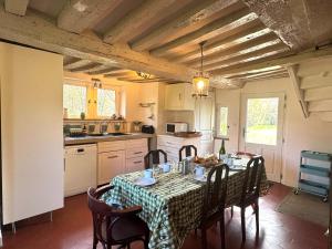 a kitchen with a table with chairs and a table cloth at Maison XVIIIe avec vue panoramique exceptionnelle - 12 pers au coeur du Pays d'Auge in Le Renouard
