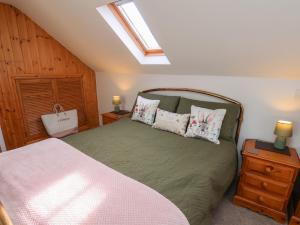 a bedroom with a green bed with pillows on it at Farm Yard Cottage in Pickering