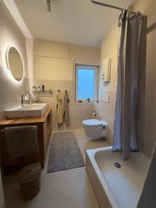 a bathroom with a tub and a sink and a toilet at Ferienhaus EifelOne - Panorama in Heimbach