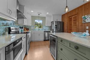 a kitchen with white cabinets and stainless steel appliances at 2444 - Sea Forever in Duck +44 photos