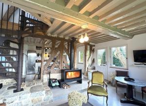 a living room with a fireplace and a staircase at Maison XVIIIe avec vue panoramique exceptionnelle - 12 pers au coeur du Pays d'Auge in Le Renouard